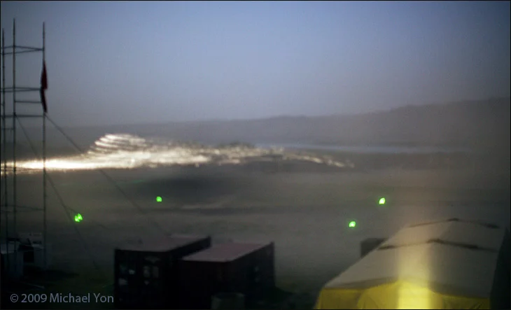 Slow shutter speed causes moving helicopter to 'disappear' while the trace and sparks off the descending rotors is clear.  Heavy dust makes a sharp focus look blurred.  (ISO 1600, 50mm at f1.2, 3.2s.)