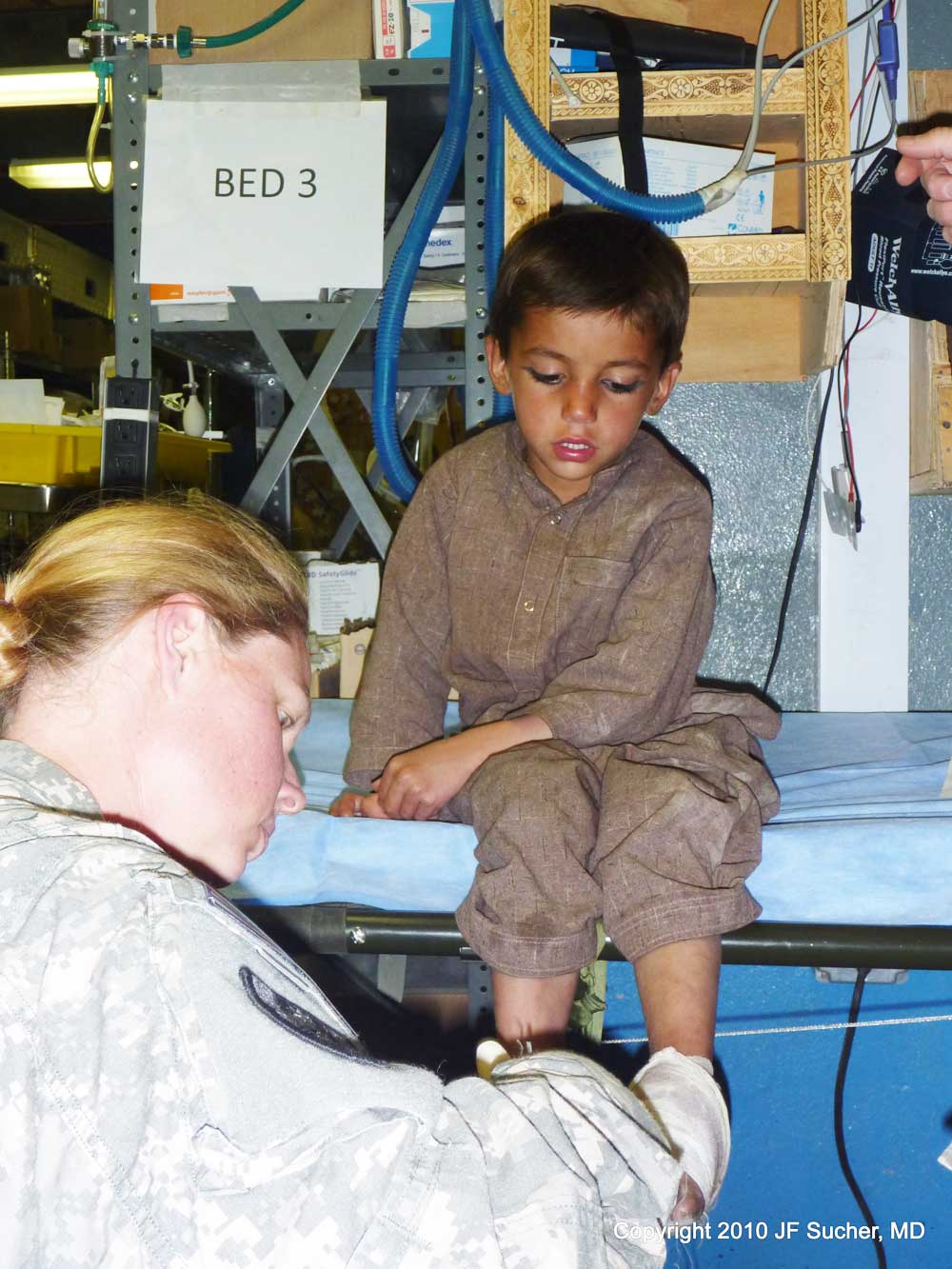 Medic from the 541st removes bandage from Orgune boy's ankle - Paktika Province, Afghanistan 2010.