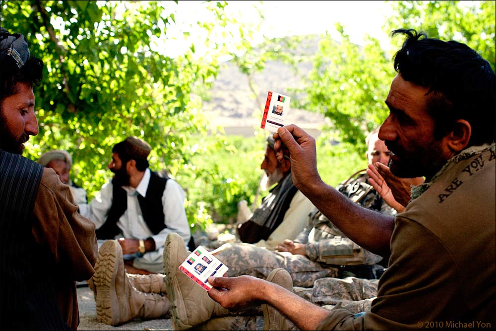 An Afghan policeman explains the ID cards to villagers in the Baghtu Valley.